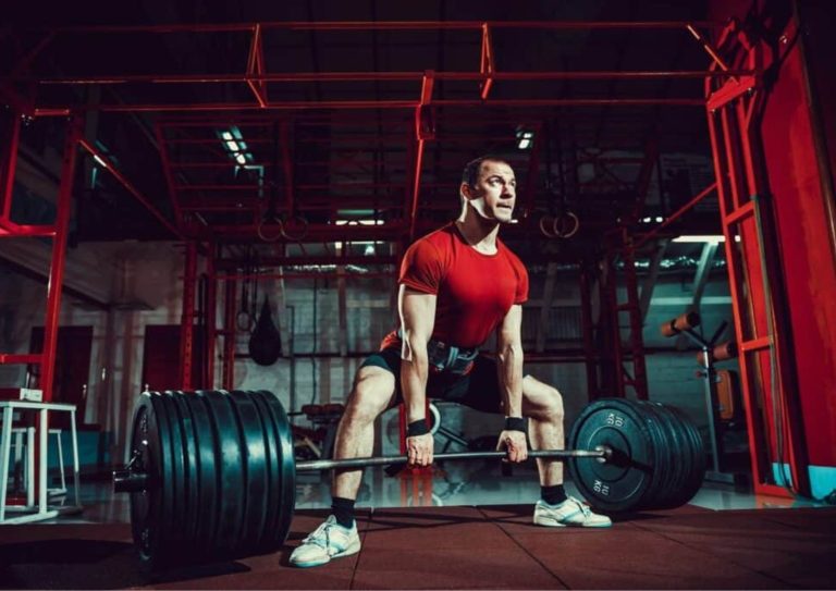 Image of a man performing one of our sumo deadlift leg workouts