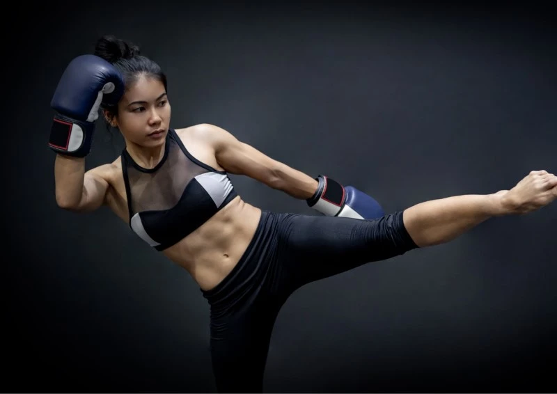 Image of a kickboxer practicing her martial art kick