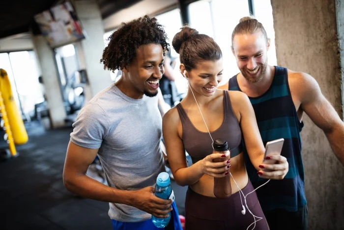 Friends reading gym success stories while working out