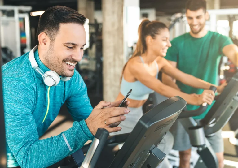 Image of a gym member looking at a gym website on his phone