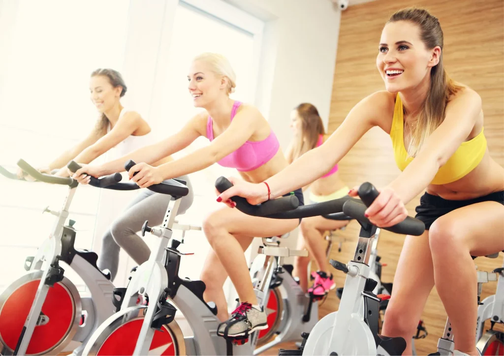 Image of women on bikes at a women only gym; representing one of the popular styles of gyms and fitness classes